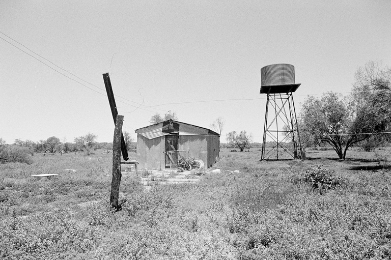 Corrugated iron structure and elevated water tank.