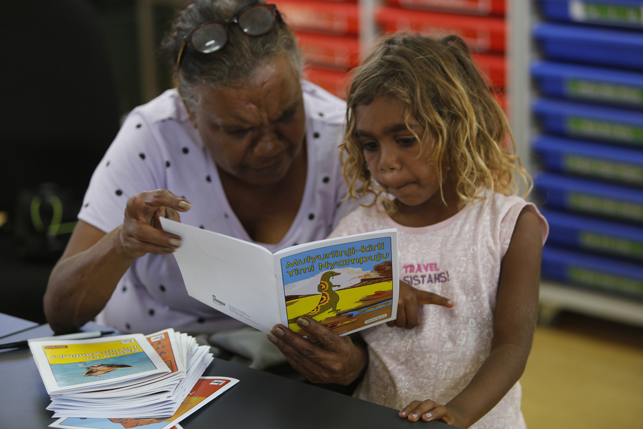 Theresa Napurrurla Ross reading to her granddaughter