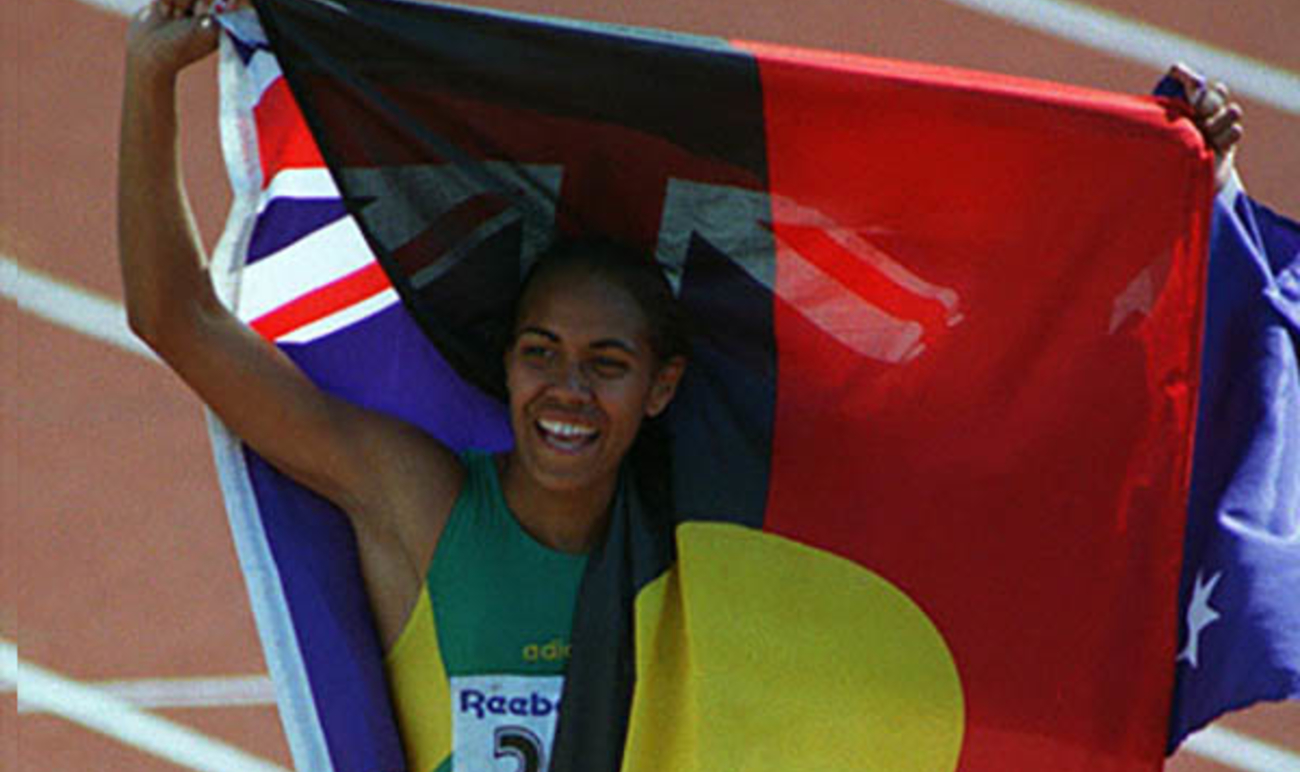 Cathy Freeman holding the Aboriginal flag and the Australian flag