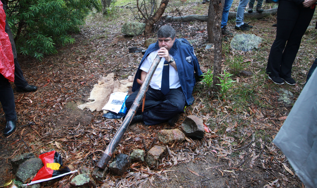 Jeff Timbery, seated playing a didgeridoo